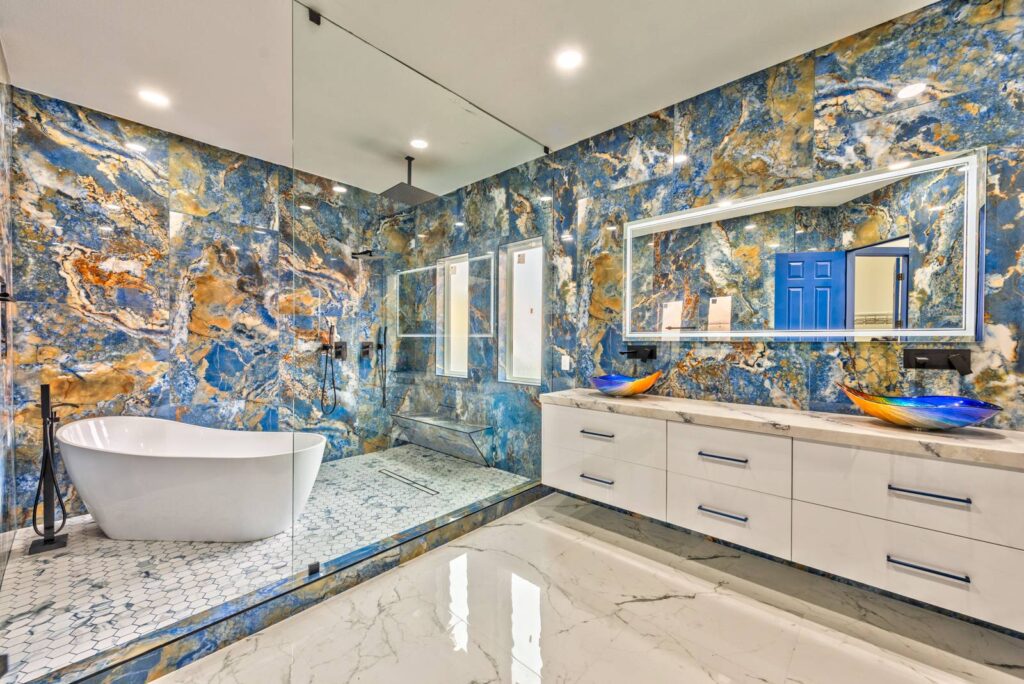 Renovated modern kitchen by M&M Restoration in Las Vegas with white cabinets and marble countertops