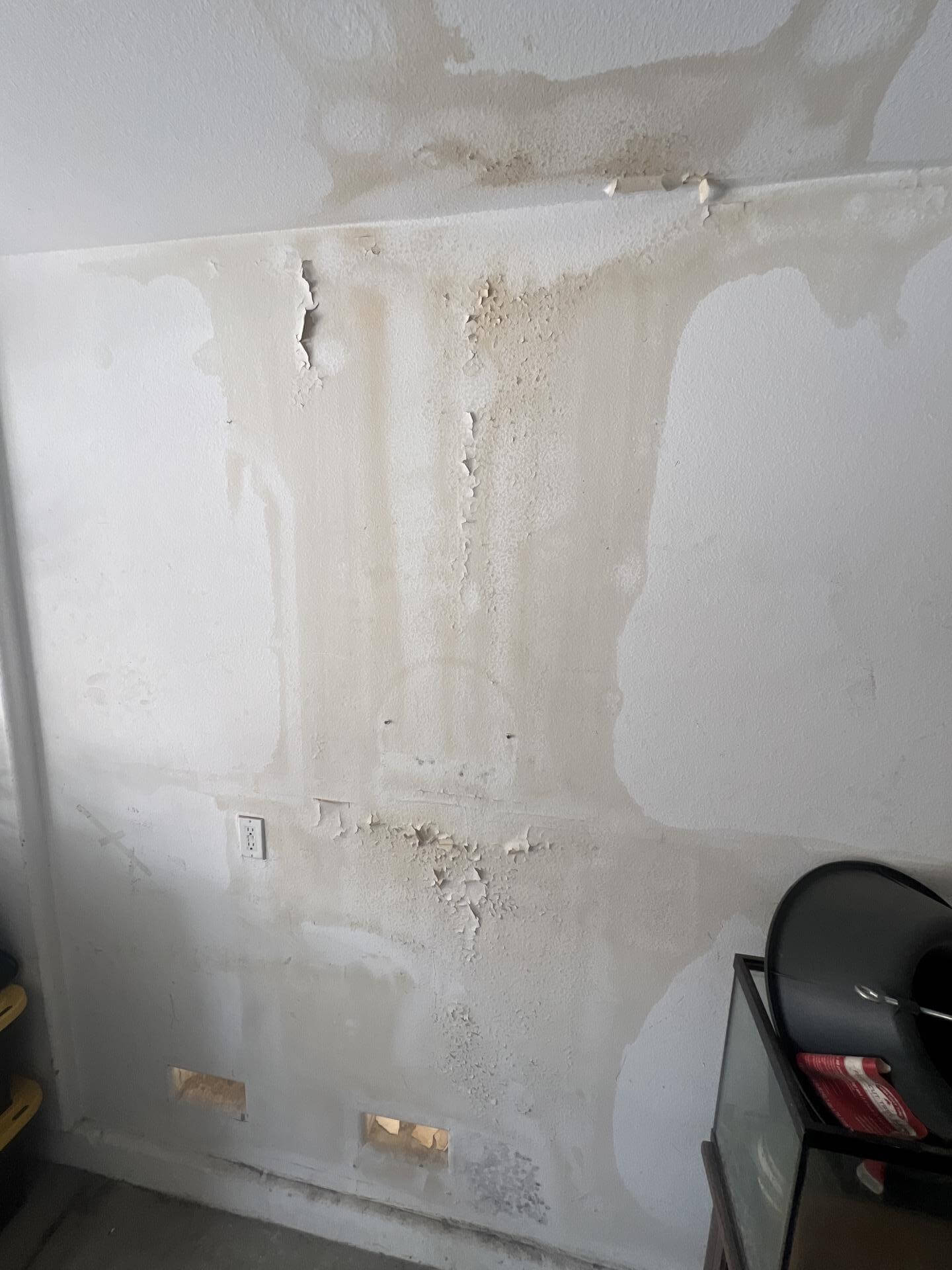 Severe wall water damage with peeling paint and visible stains