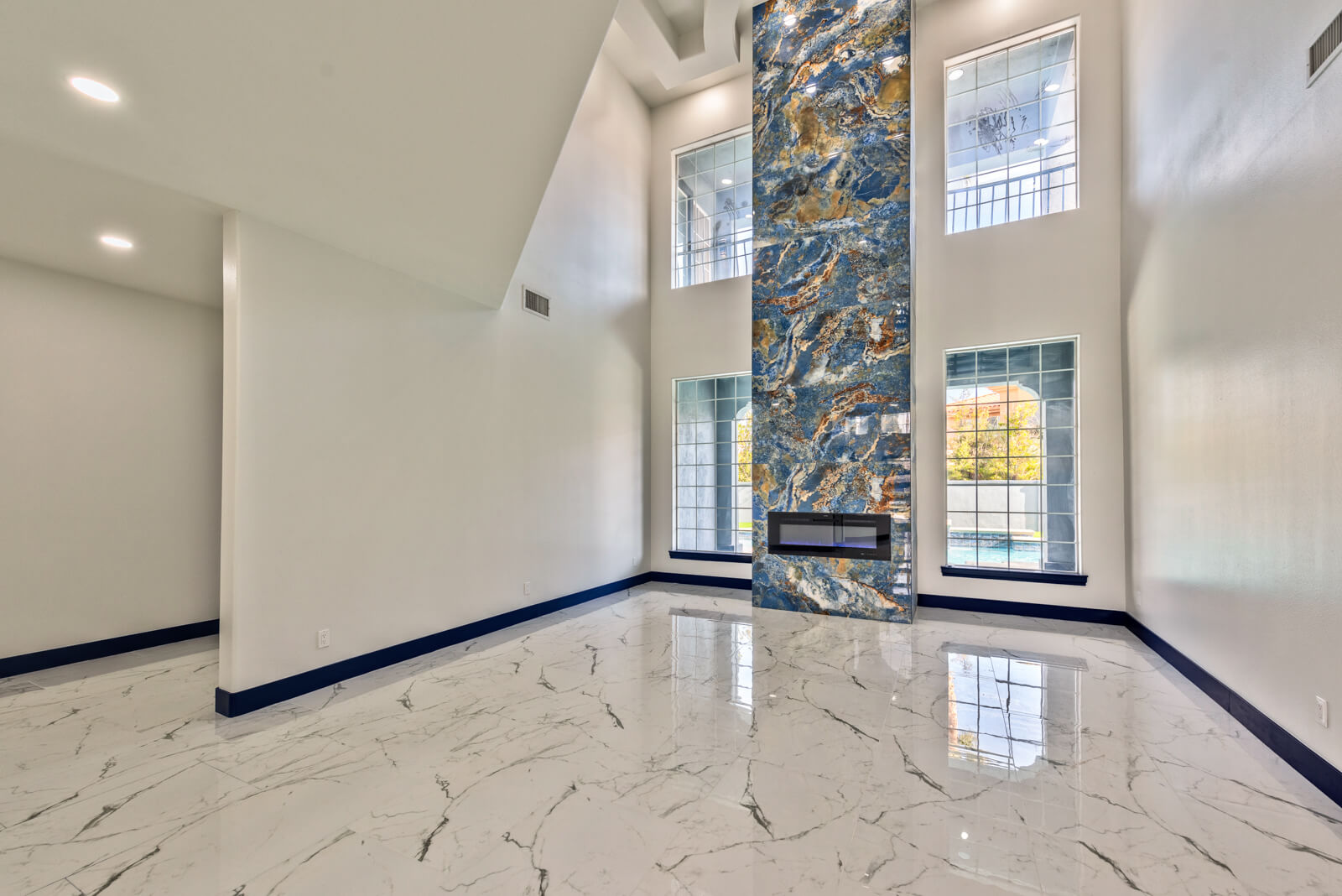 Renovated foyer with marble flooring and modern blue stone fireplace in Las Vegas