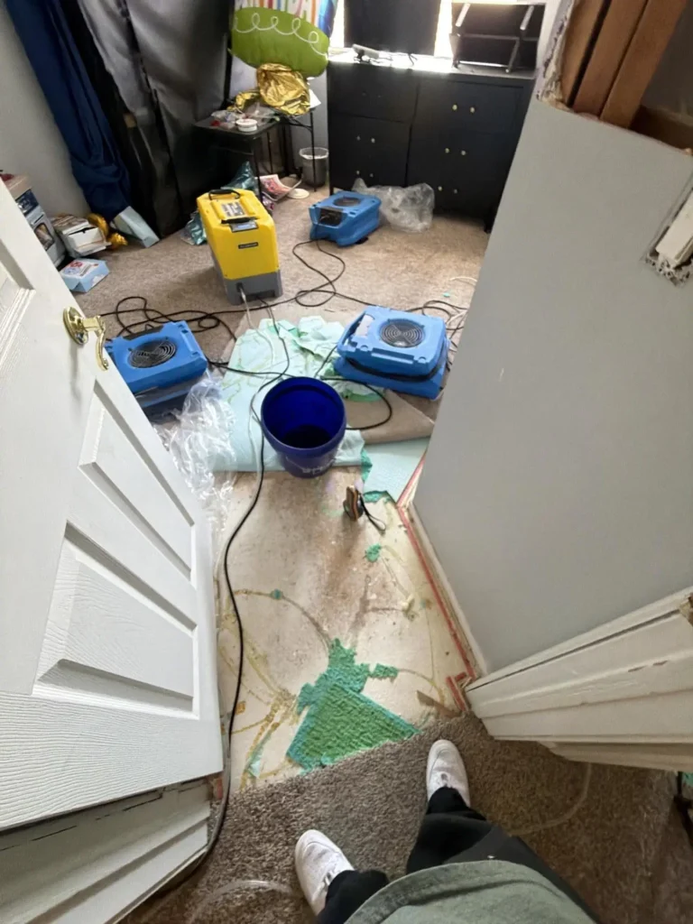 Dehumidifier and air movers drying a water-damaged bedroom in Henderson.