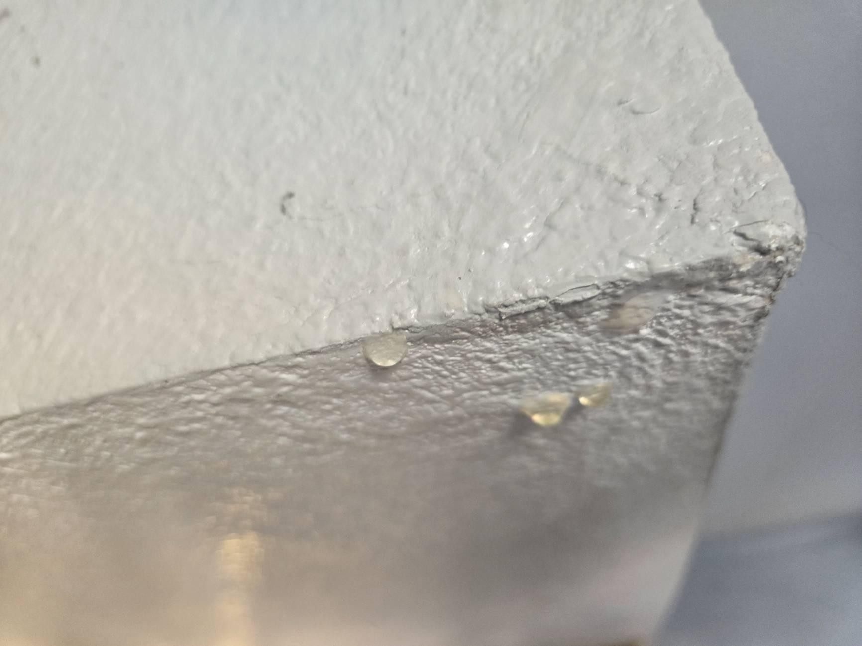 Water droplets forming on a painted surface during an AC leak inspection in a Las Vegas home