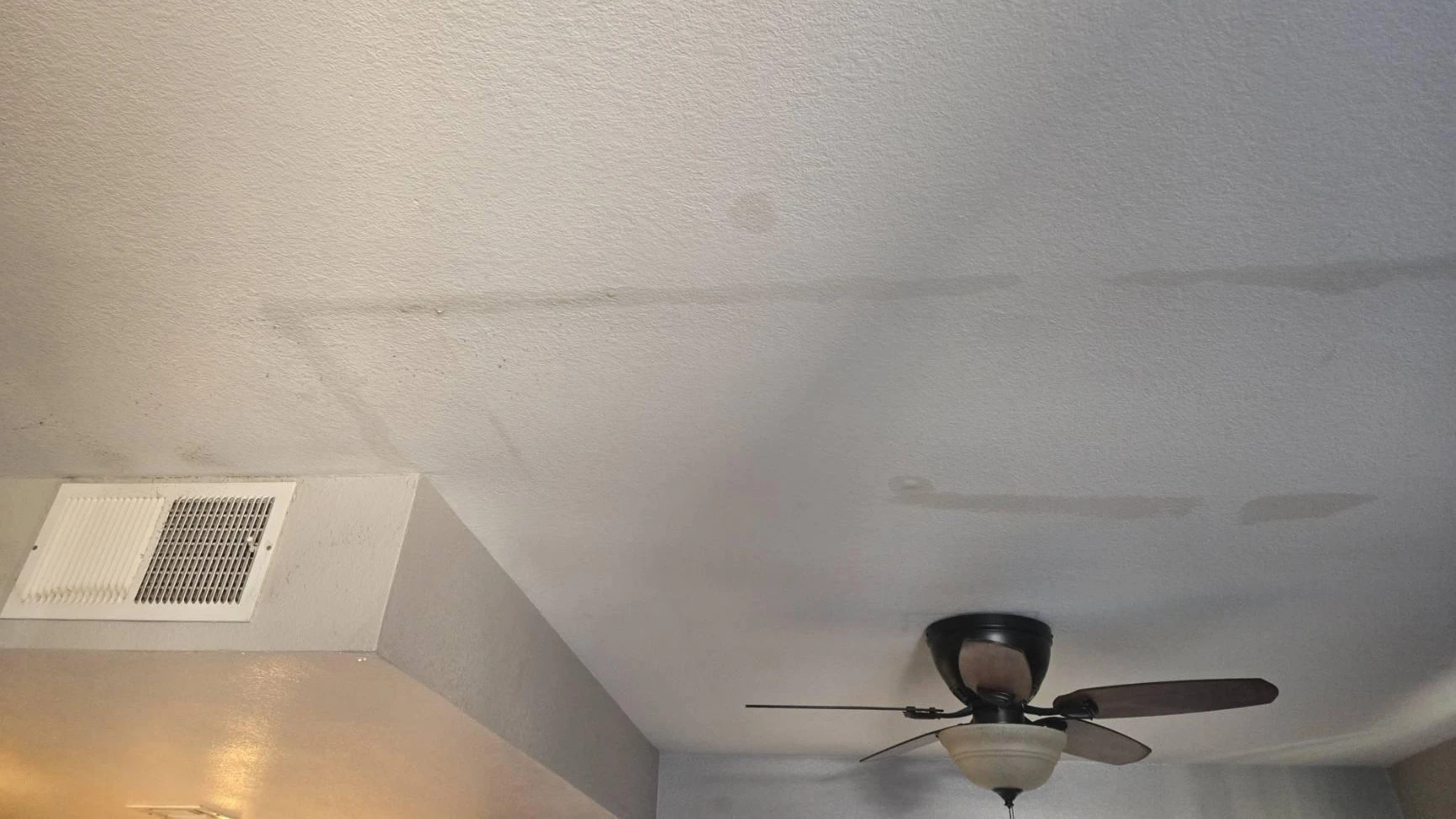 Water stains spreading across a bedroom ceiling from a leaking attic AC unit in a Las Vegas home