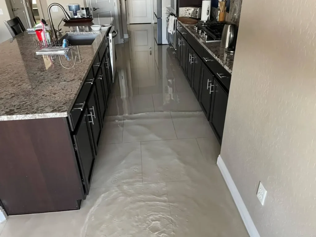 Standing water flooding a kitchen tile floor in a Paradise, LV home